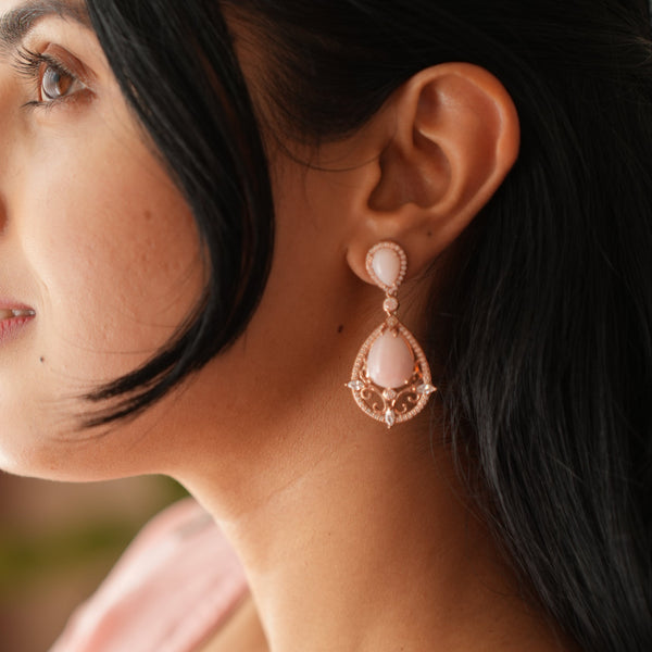Close-up of a person wearing pink earrings with a blurred background